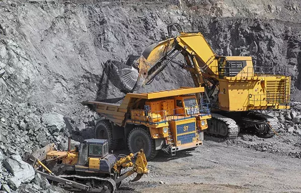 mining equipment loading iron ore and magnetite ores. into a heavy dump truck at an open pit mine